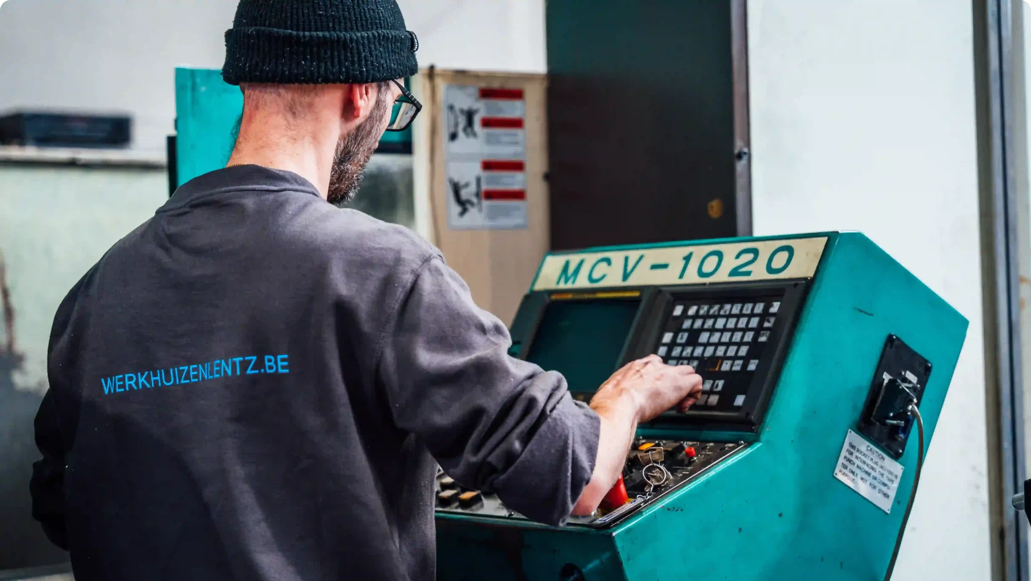 Een werknemer van Werkhuizen Lentz die aan het werk is voor een bedieningspaneel van een Dahlih 1020 machine